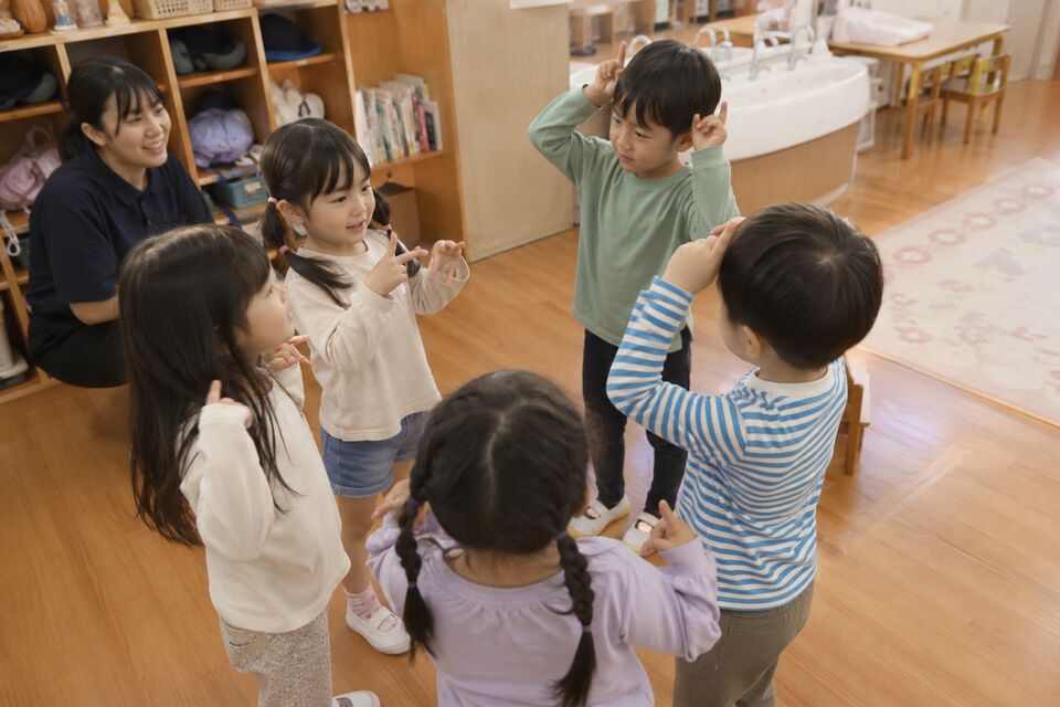 英語の歌とジェスチャーを友だち同士で楽しむ園児たち